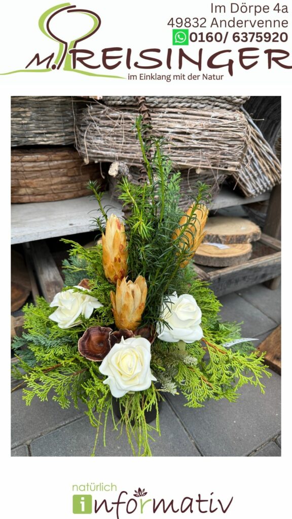 Ein florales Arrangement mit weißen Rosen, Tannenzweigen und getrockneten, braunen Blüten in einem natürlichen, rustikalen Setting. Im Hintergrund sind geflochtene Körbe und Holzscheiben sichtbar.